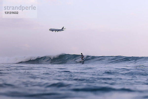 Flugzeug überfliegt Surfer im Meer