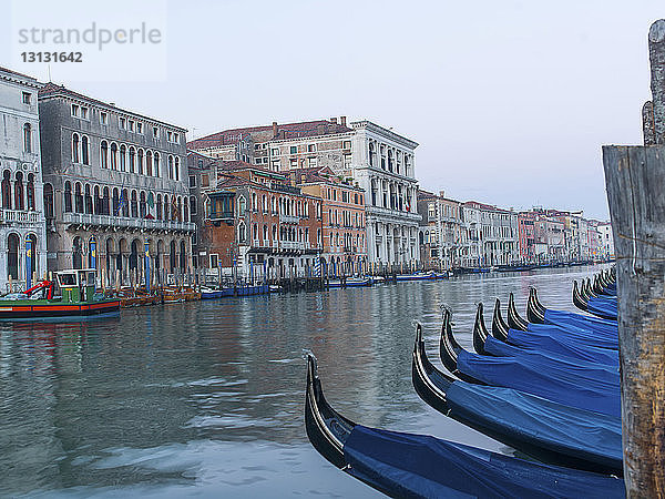 Gondeln am Canal Grande durch Gebäude gegen den klaren Himmel vertäut