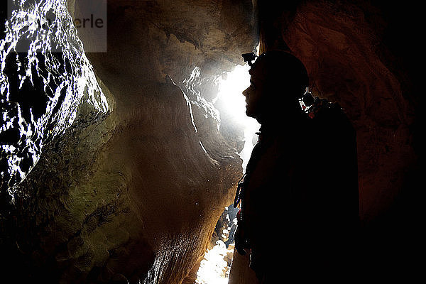 Seitenansicht eines in einer Höhle arbeitenden Menschen