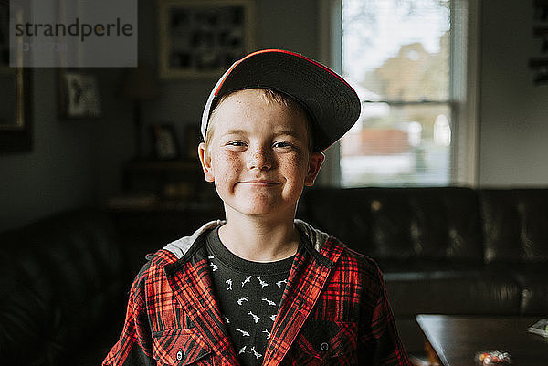 Porträt eines glücklichen Jungen mit Mütze zu Hause