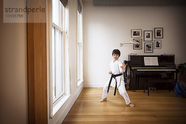 Junge übt zu Hause Karate am Fenster