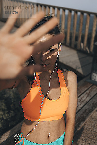 Hochwinkelporträt einer weiblichen Athletin  die bei sonnigem Wetter im Freien steht