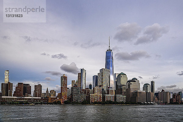 Ein World Trade Center inmitten von Gebäuden in der Stadt am Fluss gegen den Himmel