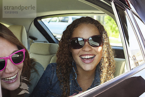 Porträt einer Teenagerin mit Freundin im Auto