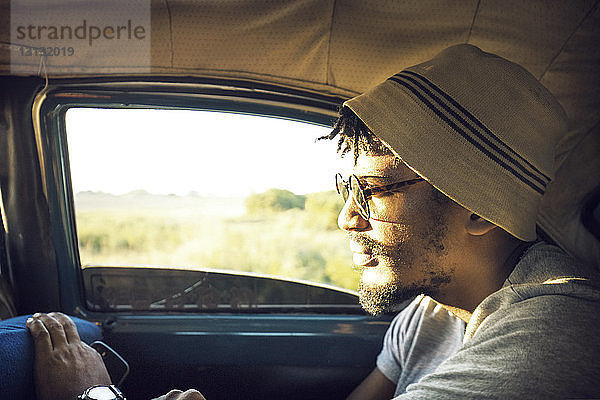 Nahaufnahme eines Mannes mit Sonnenbrille beim Autofahren