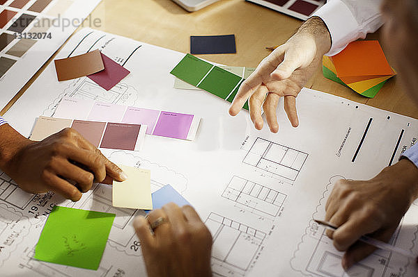 Ausgeschnittenes Bild von Geschäftsleuten  die für Farbmuster diskutieren