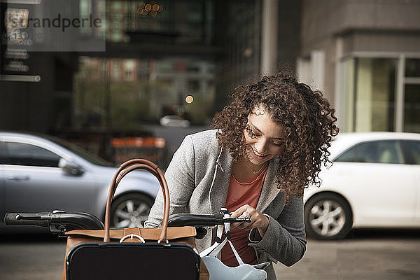 Glückliche Geschäftsfrau mit Fahrrad auf der Straße