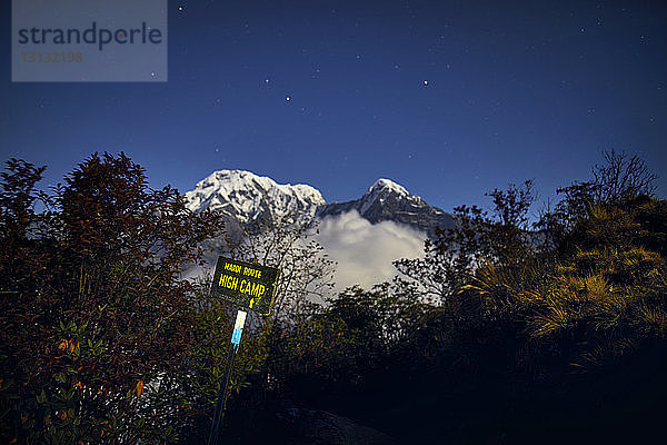 Tiefblick auf Straßenschild auf Berg gegen blauen Himmel bei Nacht