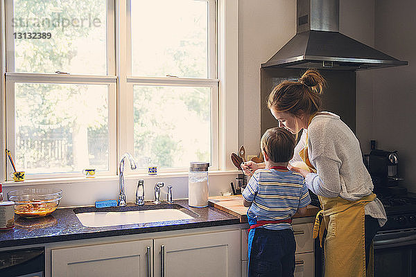 Rückansicht von Mutter und Sohn und Kochen in der Küche
