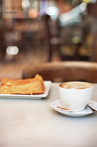 Cappuccino und Gebäck auf dem Tisch im Café serviert