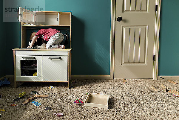 Verspielter Junge versteckt sich zu Hause im Schrank