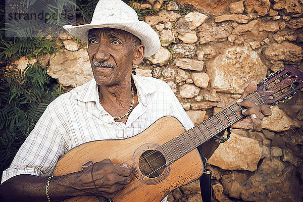 Mann schaut weg  während er Gitarre spielt