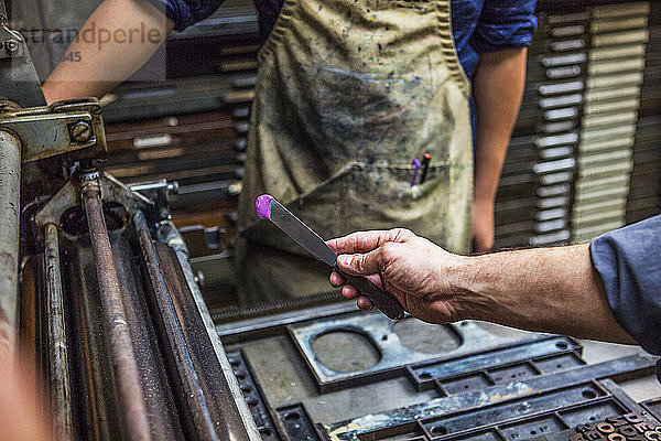 Arbeiter hält Tintenmesser in der Werkstatt