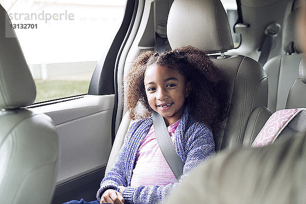 Porträt eines glücklichen Mädchens im Auto sitzend
