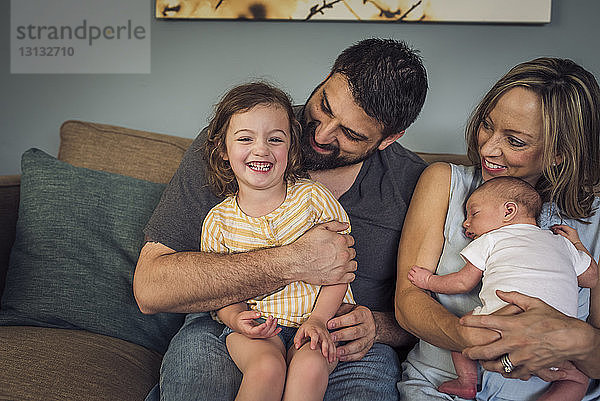 Glückliche Familie sitzt zu Hause auf dem Sofa