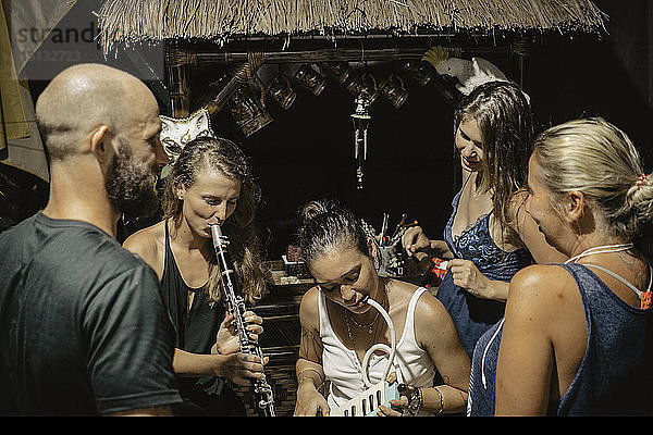 Freunde schauen auf Frauen  die Blasinstrumente in einem Touristenort spielen