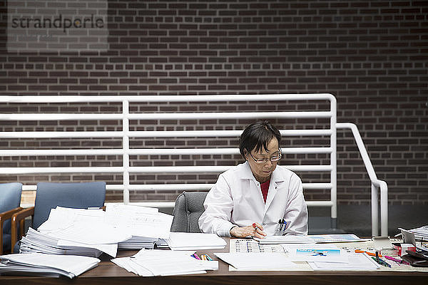 Leitende Wissenschaftlerin liest Dokumente im Labor