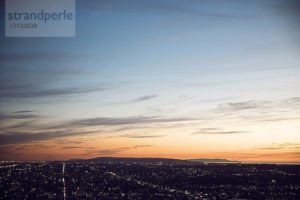 Luftaufnahme der beleuchteten Stadtlandschaft gegen den Himmel bei Sonnenuntergang