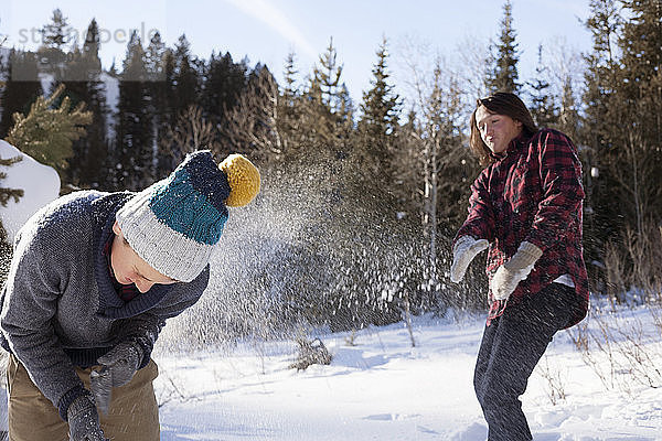 Teenager spielen mit Schnee an einem sonnigen Tag