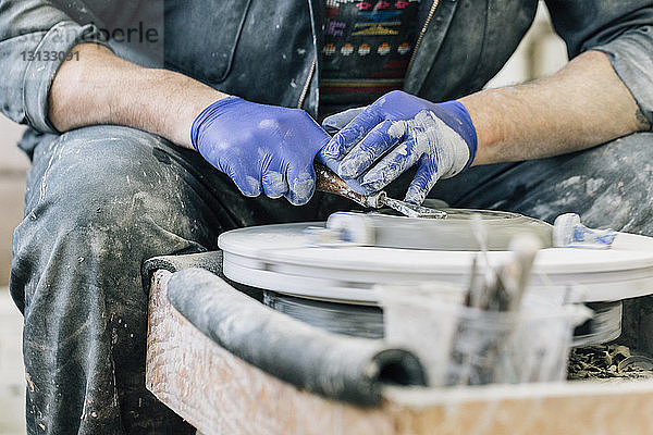 Mittelteil eines Handwerkers  der die Töpferscheibe bei der Arbeit im Kunstatelier benutzt