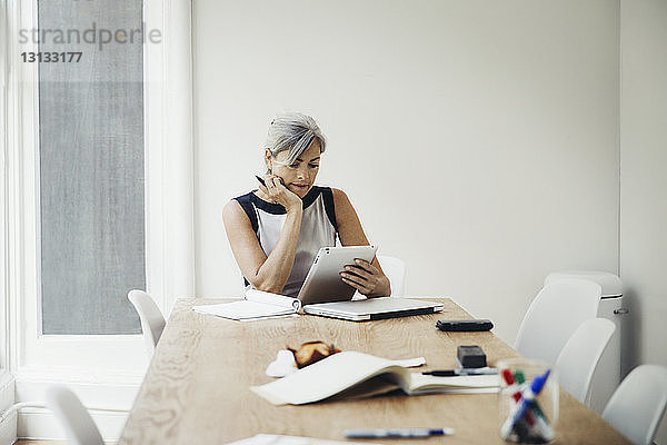 Geschäftsfrau benutzt Tablet-Computer im Sitzungssaal