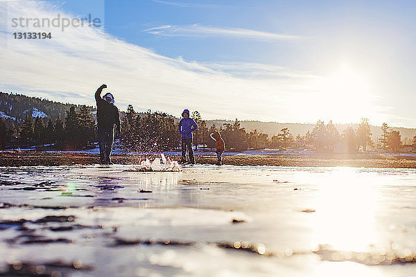 Vater steht mit Töchtern am zugefrorenen Big Bear Lake