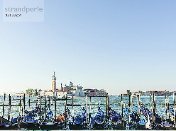 Gondeln am Canal Grande vor der Stadt vor klarem Himmel vertäut