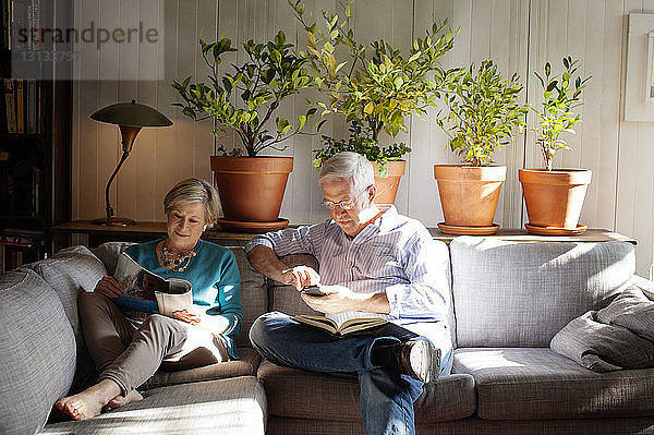 Älteres Ehepaar sitzt zu Hause auf dem Sofa