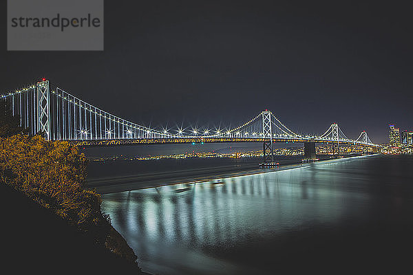 Beleuchtete Oakland Bay Bridge gegen klaren Himmel bei Nacht