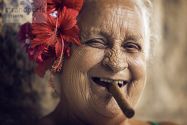 Nahaufnahme des Porträts einer Frau mit Zigarre im Mund