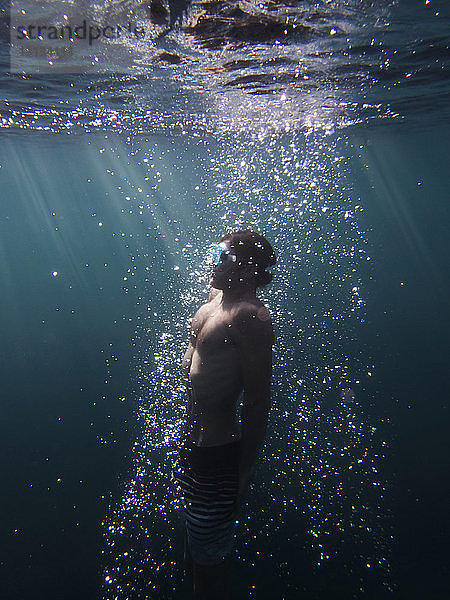 Seitenansicht eines im Meer schwimmenden Mannes
