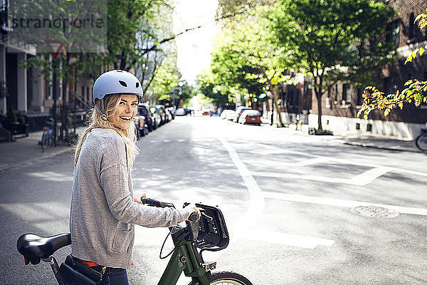 Seitenansicht Porträt einer glücklichen Frau mit Fahrrad auf der Straße