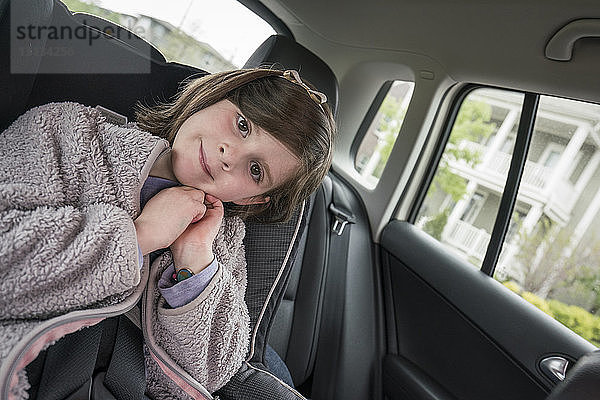 Porträt eines süßen Mädchens im Auto sitzend