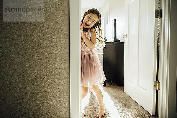 Porträt eines glücklichen Mädchens  das an der Tür steht