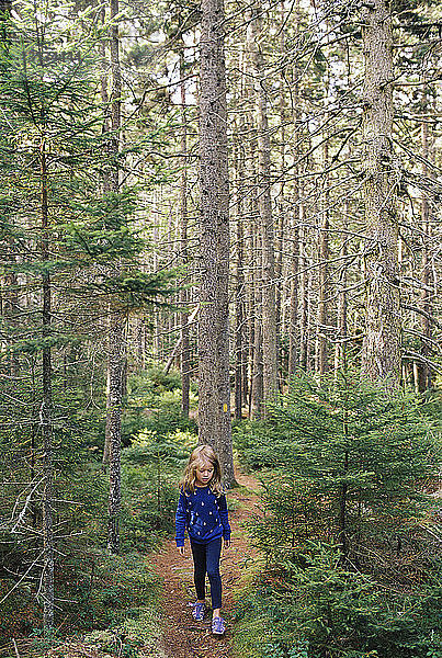 Mädchen geht auf Feldweg im Wald