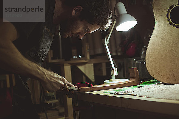 Seitenansicht eines Mannes beim Holzrasieren im Workshop