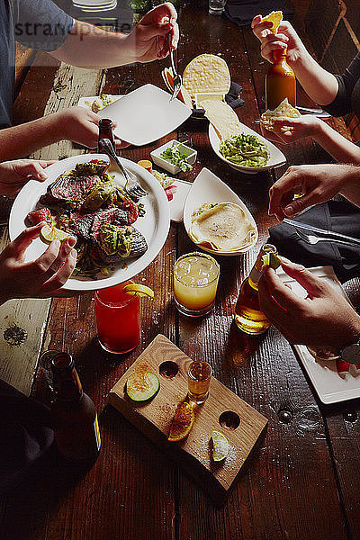 Ausgeschnittenes Bild von Menschen  die am Tisch essen