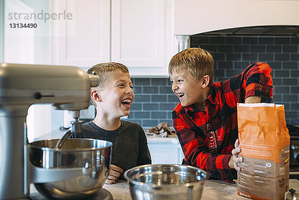 Glückliche Brüder  die zu Hause in der Küche das Essen zubereiten