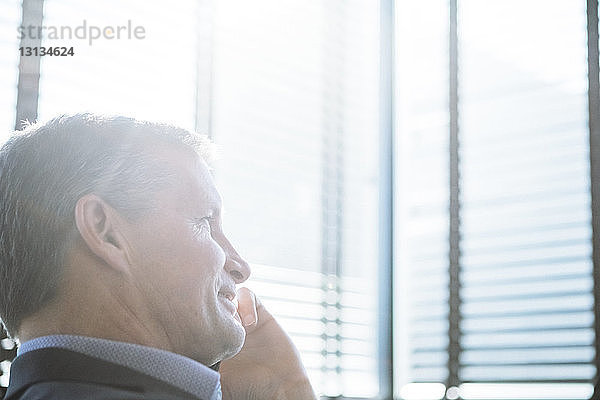 Nahaufnahme eines Geschäftsmannes  der im Büro per Handy telefoniert