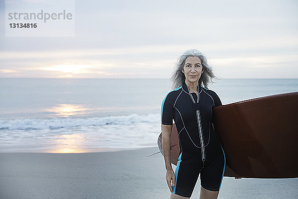 Porträt einer selbstbewussten Surferin mit Surfbrett am Delray Beach