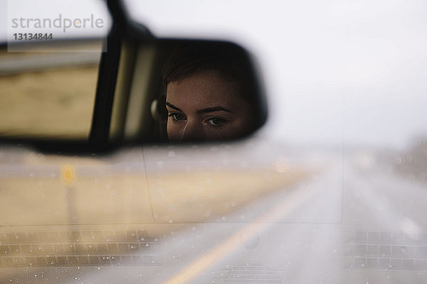 Spiegelung der Frau am Rückspiegel im Auto