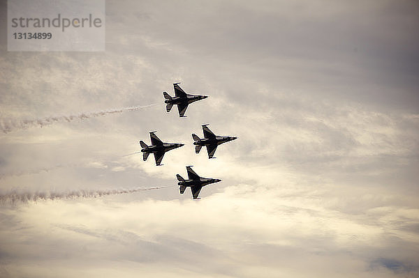 Tiefblick auf Kampfflugzeuge  die während einer Flugschau am bewölkten Himmel fliegen