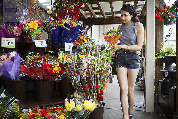 Frau wählt Blumensträuße im Blumenladen aus