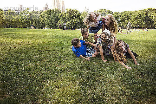 Kinder genießen mit der Mutter auf der Wiese im Park