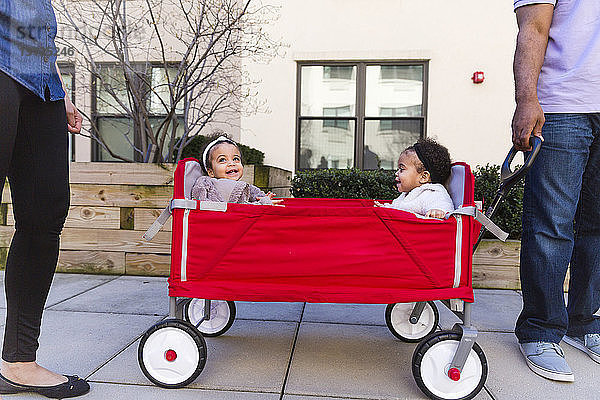 Niedriger Anteil von Eltern  die bei Töchtern stehen  die im Kinderwagen auf dem Fußweg sitzen