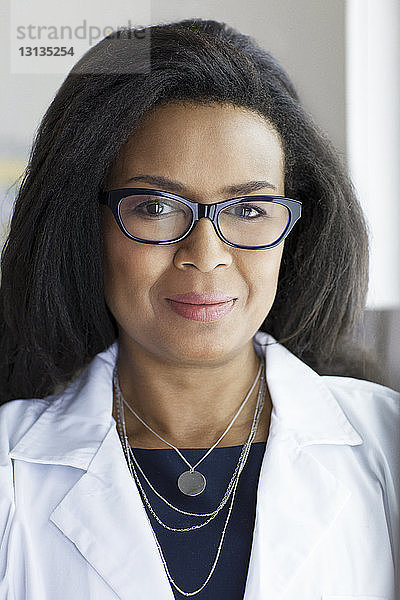 Porträt einer selbstbewussten Ärztin  die im Krankenhaus eine Brille trägt