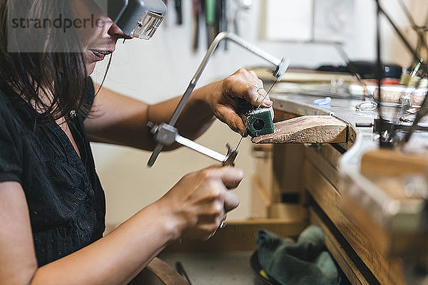 Mittelteil einer Schneidausrüstung für Handwerkerinnen mit Handsäge auf dem Tisch in der Werkstatt