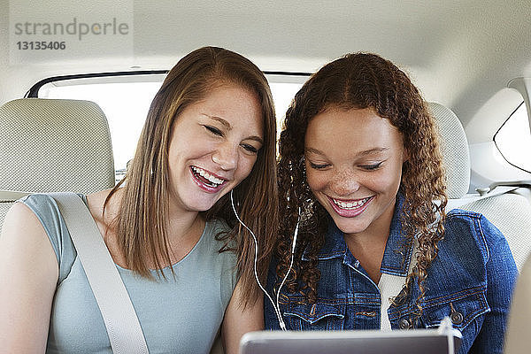 Glückliche Freunde hören Musik  während sie im Auto sitzen