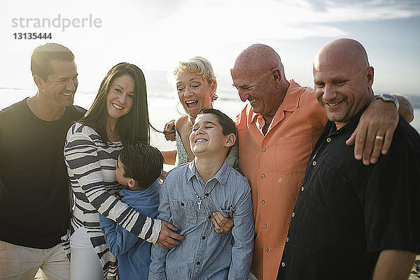 Glückliche Familie steht am Strand gegen den Himmel