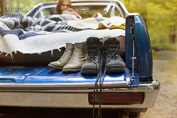 Schuhe auf Pick-up mit entspannendem Paar im Hintergrund